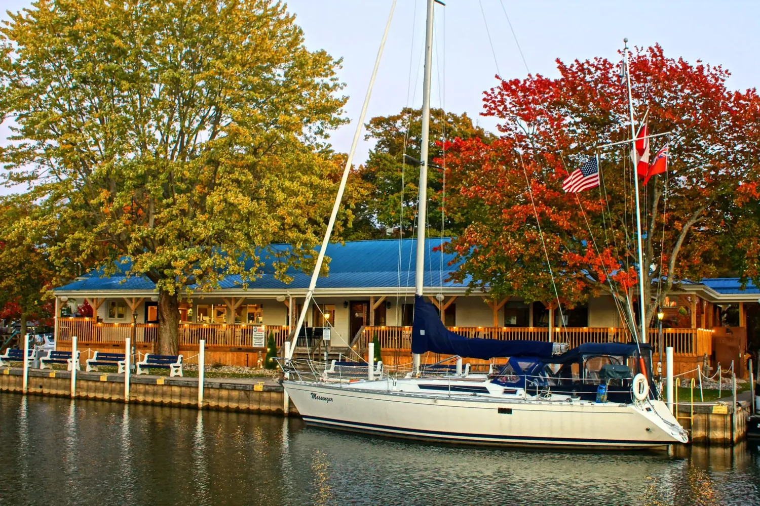 A sailboat moored in front of the Baie-D’Urfé Yacht Club clubhouse in the fall