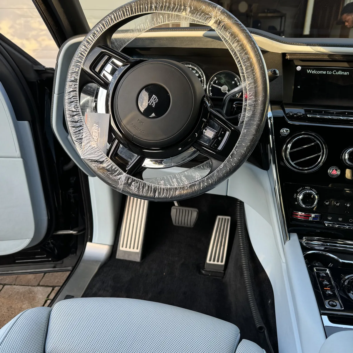 Rolls-Royce Cullinan interior detail, steering wheel under a fresh protective wrap