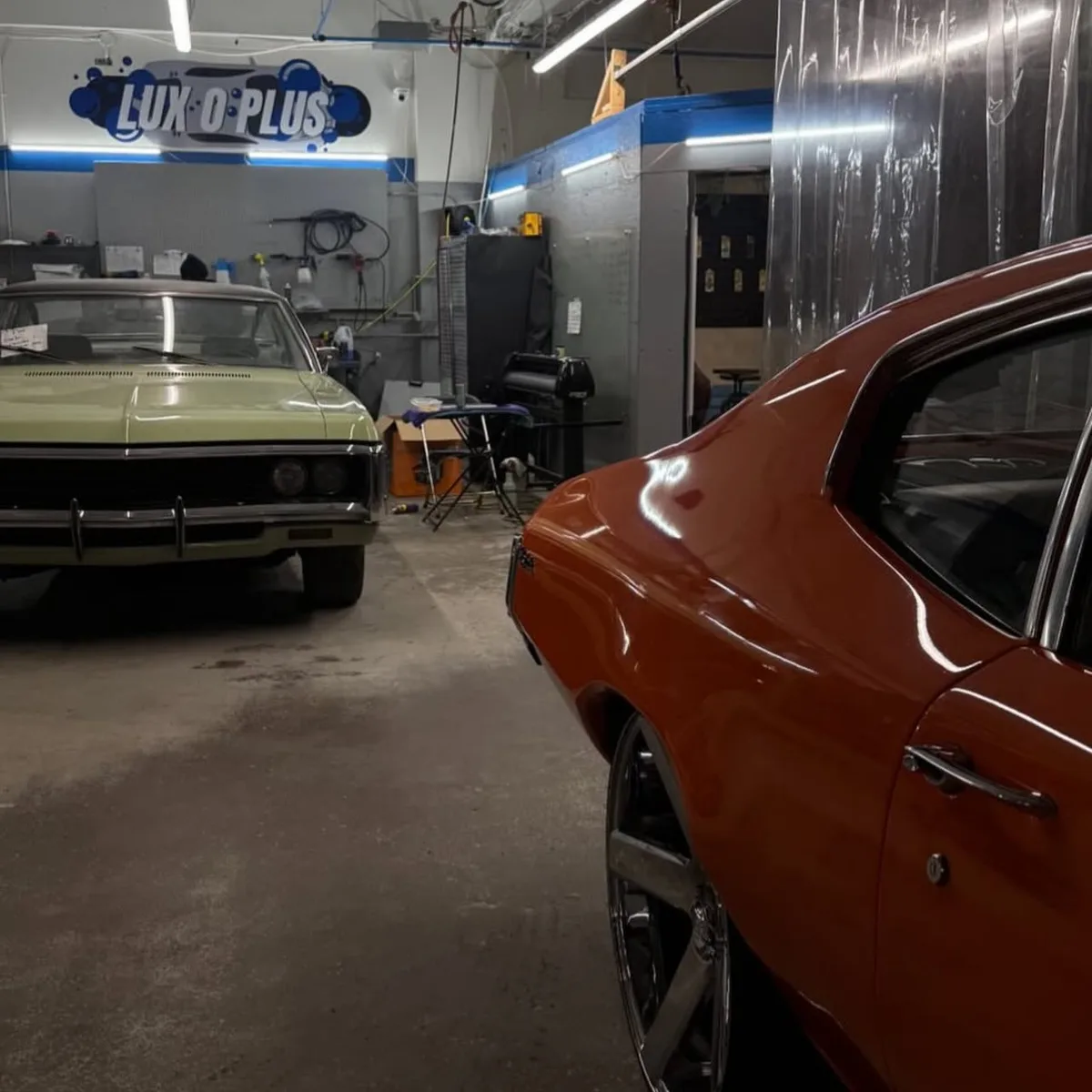 Two classic cars in the bay at the LUXOPLUS shop on Van Horne